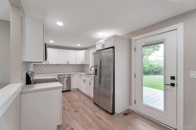 8280 Auburn Ln, Westminster, CO 80031 - kitchen featuring stainless steel appliances, light wood-type flooring, light countertops, backsplash, and white cabinetry