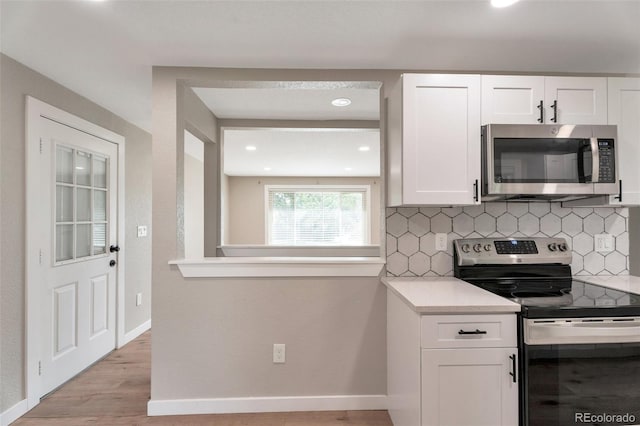 8280 Auburn Ln, Westminster, CO 80031 - kitchen with appliances with stainless steel finishes, tasteful backsplash, white cabinets, light countertops, and light wood-style floors