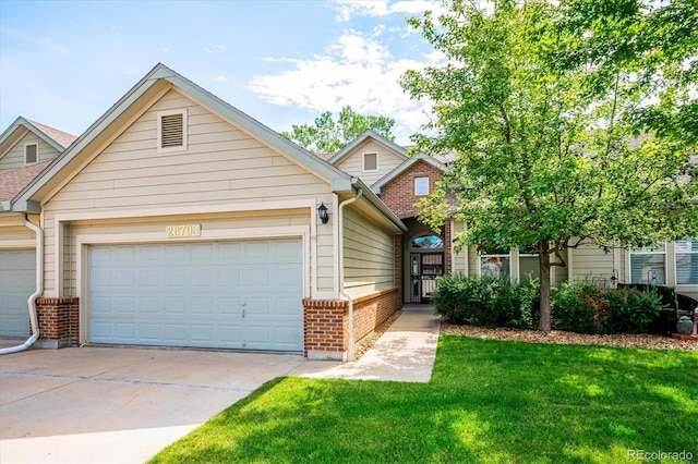 2870 W Riverwalk Cir Unit B, Littleton, CO 80123 - view of front facade featuring brick siding, driveway, and a garage