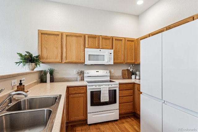 2870 W Riverwalk Cir Unit B, Littleton, CO 80123 - kitchen featuring white appliances, light countertops, light wood-style floors, recessed lighting, and brown cabinets