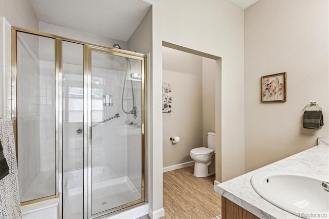 2870 W Riverwalk Cir Unit B, Littleton, CO 80123 - bathroom with a shower stall, double vanity, and wood finished floors