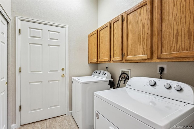 2870 W Riverwalk Cir Unit B, Littleton, CO 80123 - laundry room with cabinet space, washer and clothes dryer, and light wood-style flooring