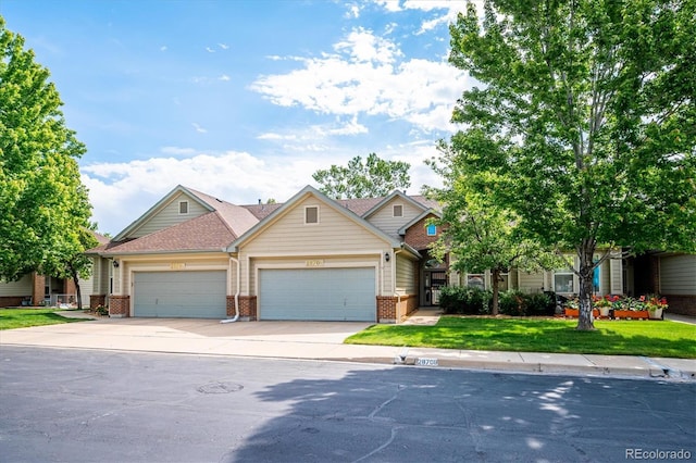 2870 W Riverwalk Cir Unit B, Littleton, CO 80123 - view of front of property with brick siding, an attached garage, concrete driveway, and a front lawn