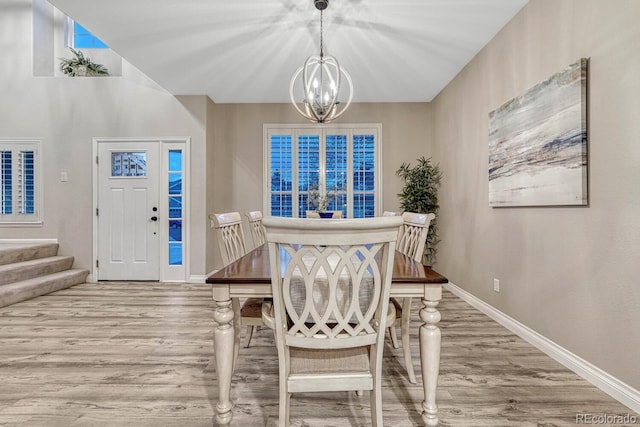 dining space with stairway, baseboards, wood finished floors, and a chandelier