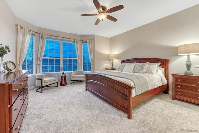 bedroom featuring ceiling fan, light colored carpet, and baseboards