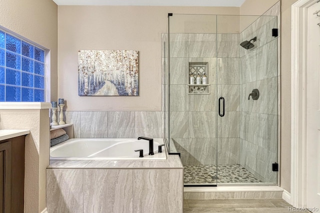 bathroom featuring vanity, a bath, and a shower stall