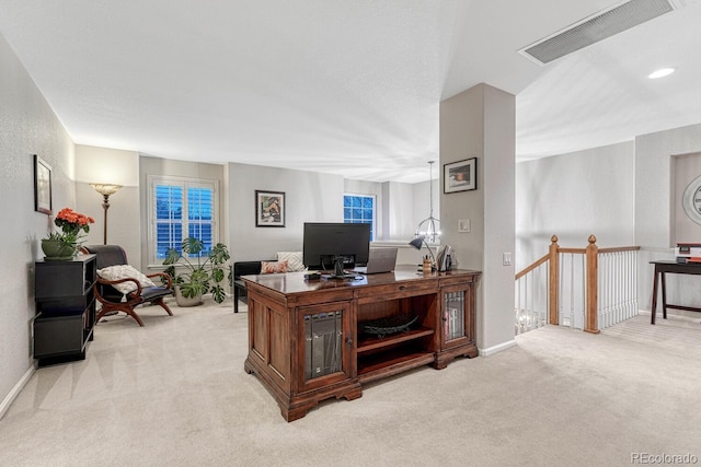 home office with baseboards, light carpet, and visible vents