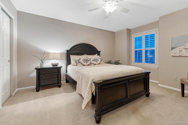 bedroom with baseboards, light carpet, ceiling fan, and a closet