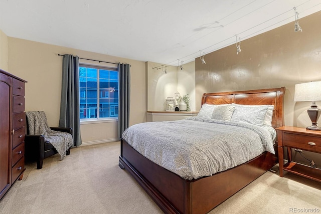 bedroom with light colored carpet and baseboards