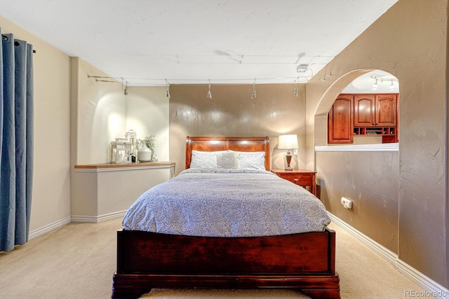 bedroom with light colored carpet and baseboards