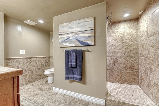 bathroom with visible vents, tile walls, a tile shower, tile patterned floors, and toilet