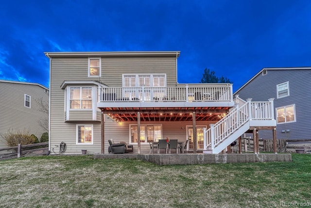 back of property with fence, stairs, a wooden deck, a patio area, and a lawn