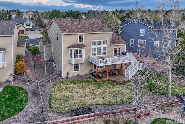 rear view of house featuring a wooden deck, a patio, a fenced backyard, stairs, and a residential view
