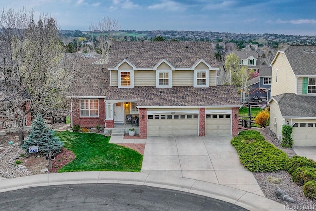 traditional home featuring a front yard, brick siding, concrete driveway, an attached garage, and a shingled roof
