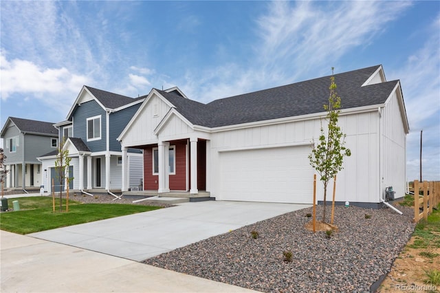 view of front of house with an attached garage, concrete driveway, board and batten siding, covered porch, and roof with shingles