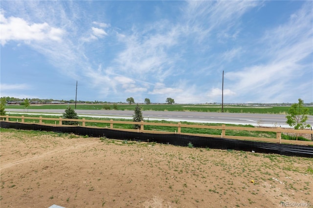 view of yard featuring fence and a view of rural / pastoral area