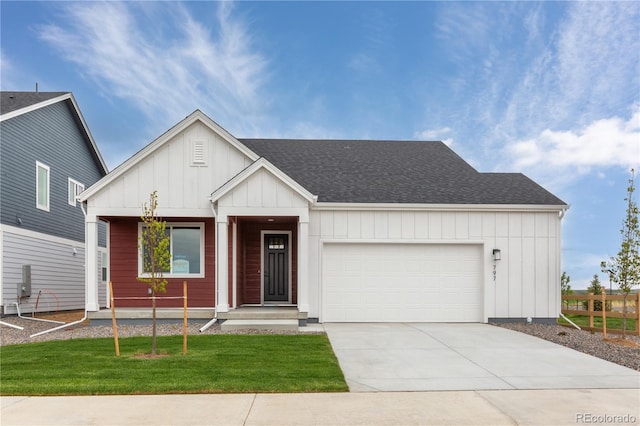 modern farmhouse featuring a garage, board and batten siding, concrete driveway, a shingled roof, and a front yard