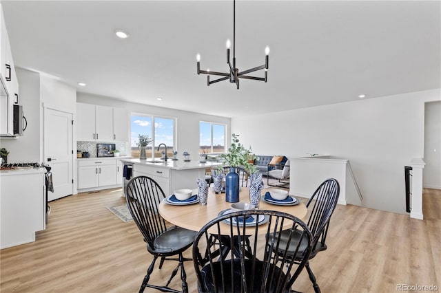 dining room with a chandelier, light wood-style flooring, and recessed lighting