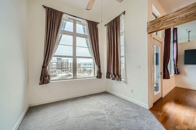carpeted empty room with baseboards, a ceiling fan, and plenty of natural light
