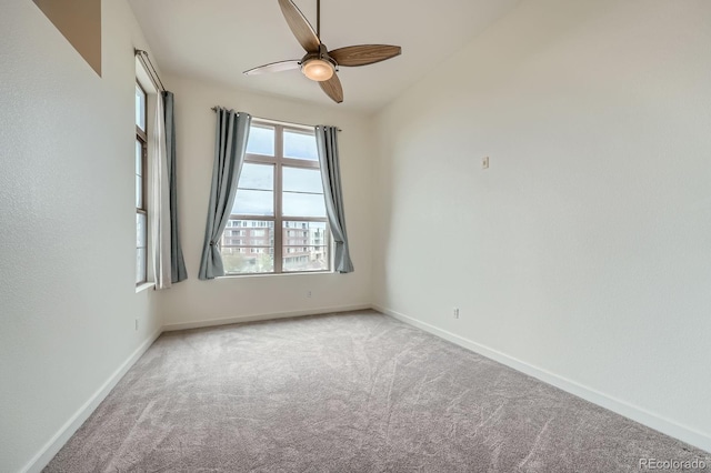spare room featuring ceiling fan, carpet, and baseboards
