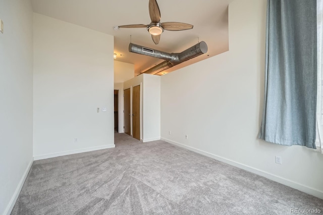 empty room featuring carpet flooring, baseboards, and a ceiling fan