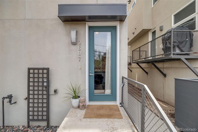 doorway to property featuring stucco siding