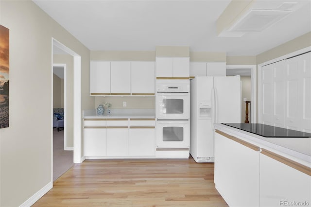 7504 E Jefferson Dr, Denver, CO 80237 - kitchen with white appliances, light wood finished floors, white cabinets, and light countertops