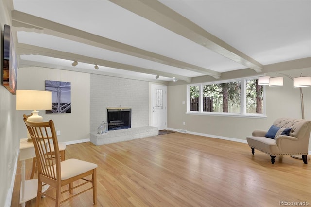 7504 E Jefferson Dr, Denver, CO 80237 - living area featuring beamed ceiling, baseboards, light wood-type flooring, and a brick fireplace
