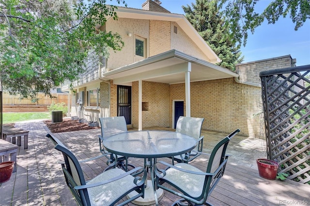 7504 E Jefferson Dr, Denver, CO 80237 - back of house featuring outdoor dining space, brick siding, a deck, and a chimney
