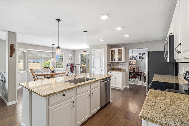 kitchen with a kitchen island with sink, sink, white cabinetry, and appliances with stainless steel finishes