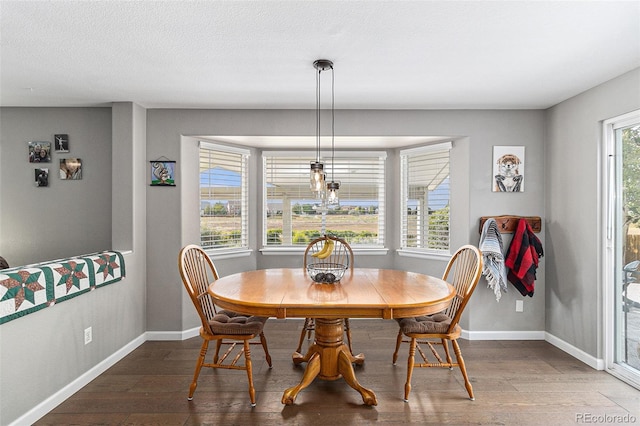 dining space with hardwood / wood-style floors and a textured ceiling