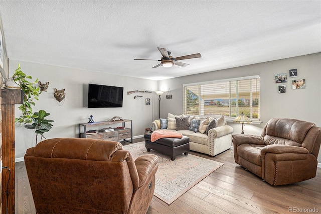 living room with a textured ceiling, light hardwood / wood-style flooring, and ceiling fan