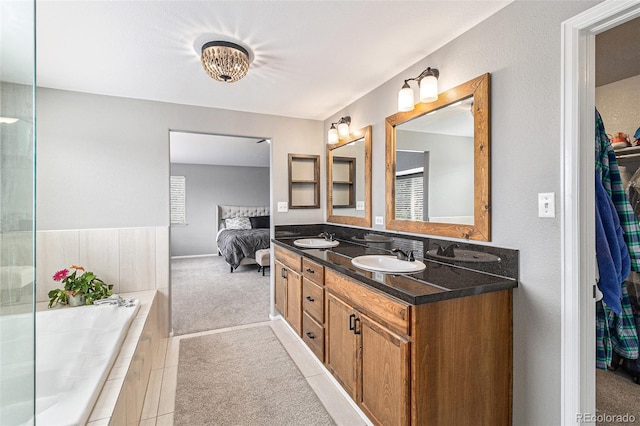 bathroom featuring vanity and tiled bath