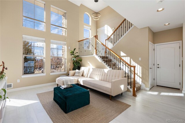 9228 Sori Ln, Highlands Ranch, CO 80126 - tiled living room featuring stairs, baseboards, a towering ceiling, and recessed lighting