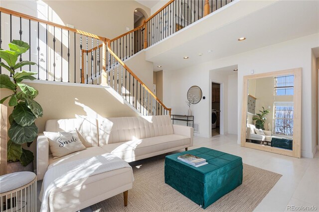 9228 Sori Ln, Highlands Ranch, CO 80126 - living room featuring a high ceiling, stairway, washer / clothes dryer, and baseboards