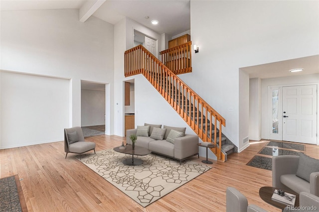 4603 S Abilene Cir, Aurora, CO 80015 - living room featuring high vaulted ceiling, stairway, beam ceiling, wood finished floors, and baseboards