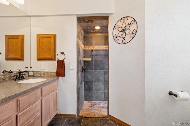 bathroom with vanity and tiled shower