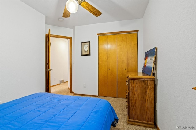 bedroom featuring ceiling fan, light carpet, and a closet