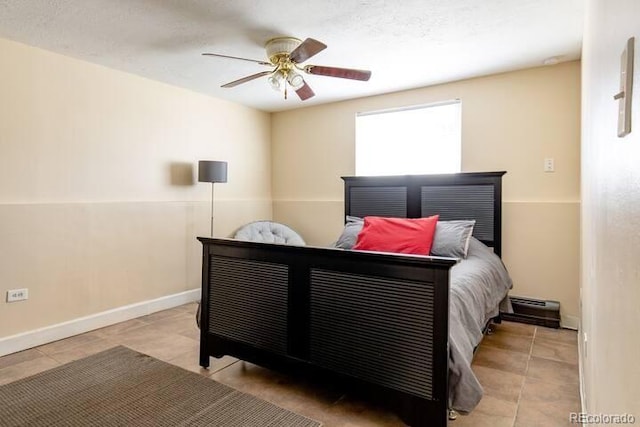 5401 E Warren Ave Unit 105, Denver, CO 80222 - tiled bedroom featuring ceiling fan and a baseboard radiator