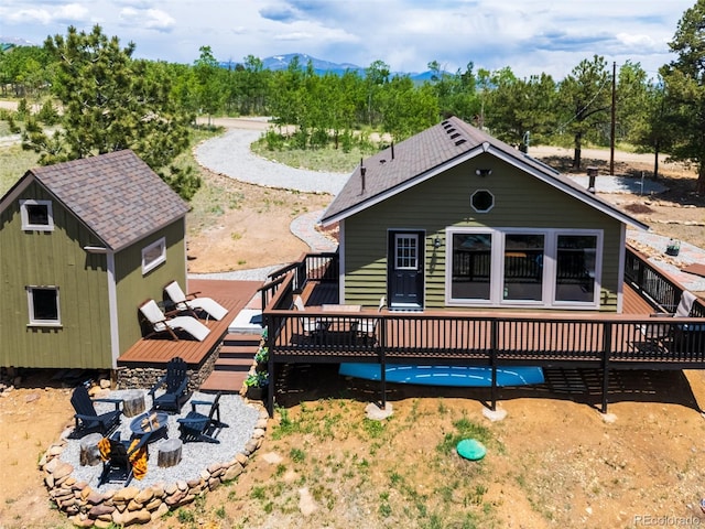 1040 Sheep Ridge Rd, Fairplay, CO 80440 - view of front facade with a fire pit, a deck with mountain view, an outbuilding, and a patio
