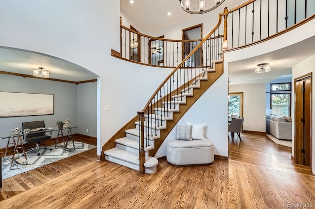 16247 E Belleview Pl, Centennial, CO 80015 - stairway with wood finished floors, a high ceiling, a chandelier, and arched walkways
