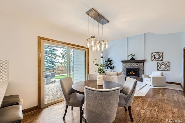 16247 E Belleview Pl, Centennial, CO 80015 - dining room featuring wood finished floors, a lit fireplace, and a chandelier