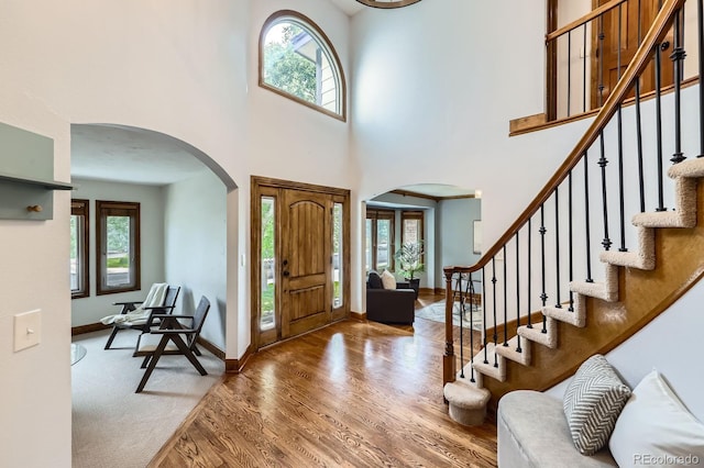 16247 E Belleview Pl, Centennial, CO 80015 - foyer with arched walkways, plenty of natural light, wood finished floors, stairs, and a towering ceiling