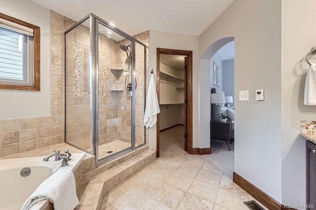 16247 E Belleview Pl, Centennial, CO 80015 - bathroom featuring a garden tub, a shower stall, a walk in closet, and tile patterned flooring