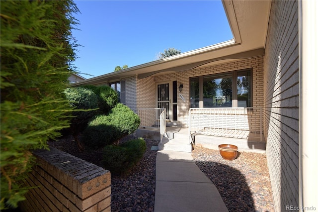 3820 S Harlan St, Denver, CO 80235 - view of exterior entry with brick siding and a porch