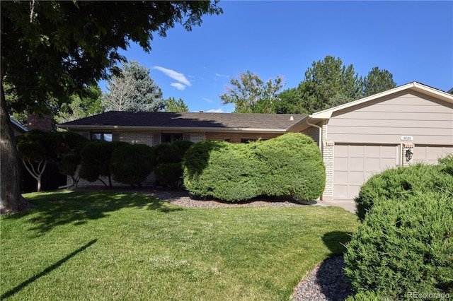 3820 S Harlan St, Denver, CO 80235 - ranch-style house with a garage, a front yard, and brick siding