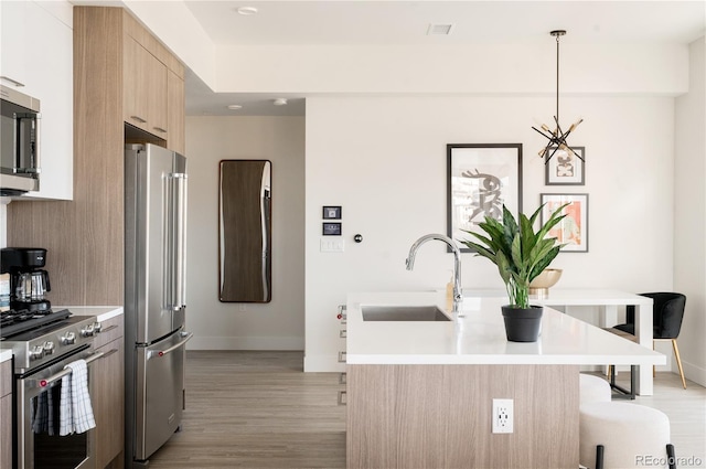 2880 Zuni St Unit 404, Denver, CO 80211 - kitchen with high quality appliances, light brown cabinets, light wood-style flooring, and light countertops