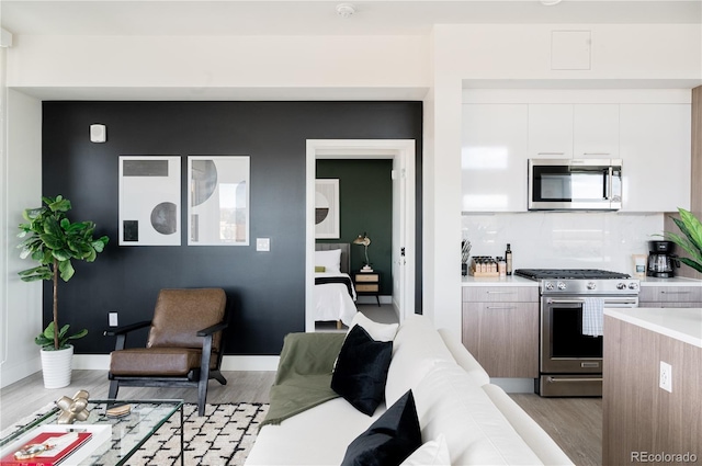 2880 Zuni St Unit 404, Denver, CO 80211 - kitchen with appliances with stainless steel finishes, light wood-style flooring, light countertops, white cabinetry, and modern cabinets