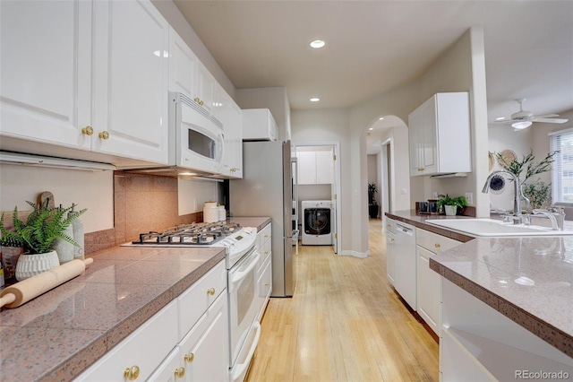 490 Jackson St, Denver, CO 80206 - kitchen featuring white appliances, a sink, tile countertops, washer / dryer, and light wood finished floors