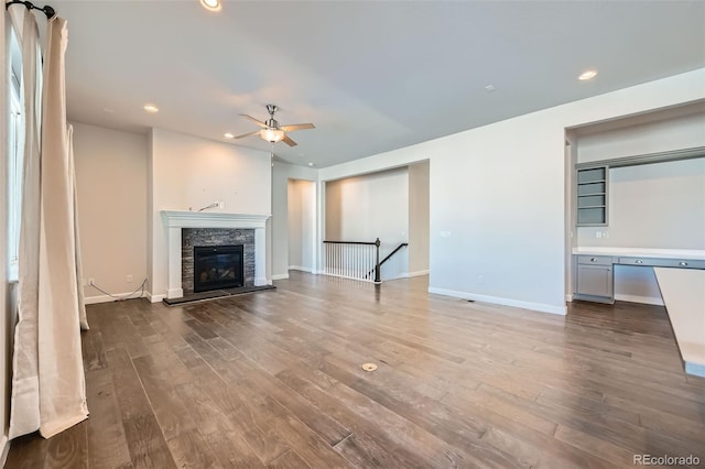 unfurnished living room featuring a fireplace, hardwood / wood-style flooring, and ceiling fan